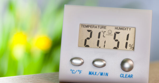 Hygrometer on a table displaying temperature and humidity
