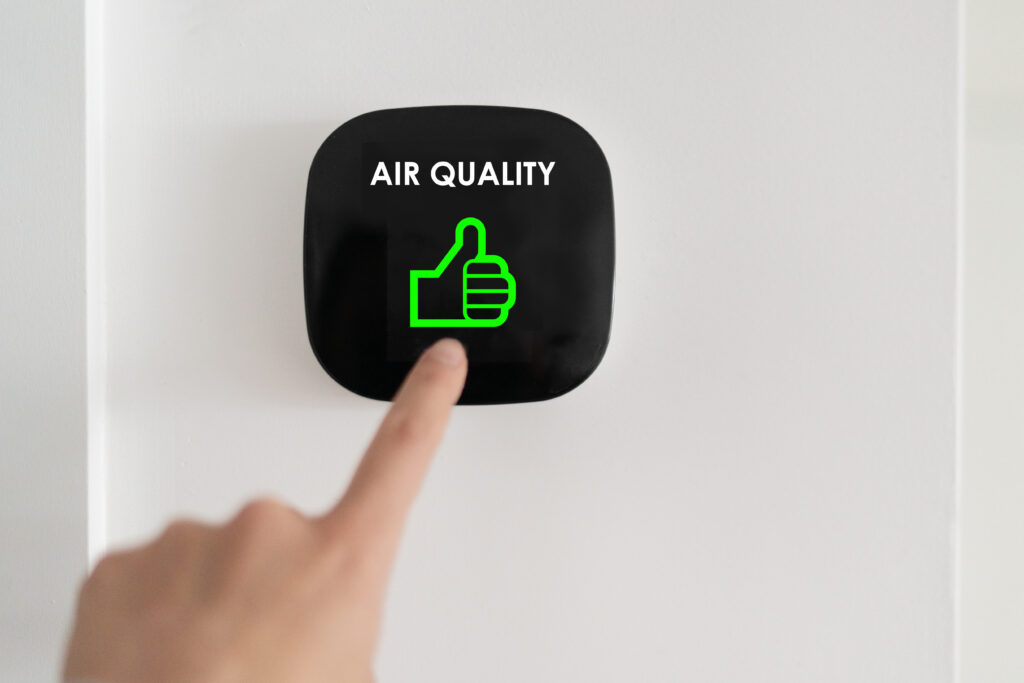 Finger touching a touchscreen system with the words "air quality" and a green thumbs up