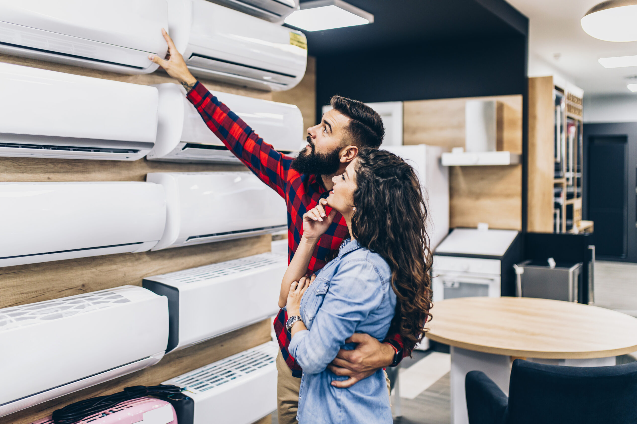 Couple looking at split system air conditioners in store