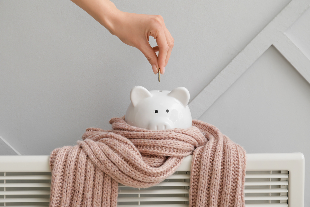 Woman putting money in a scarf-wrapper piggy bank on a radiator