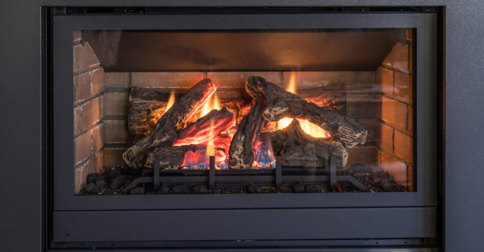 Gas fireplace logs and flames in black metal frame