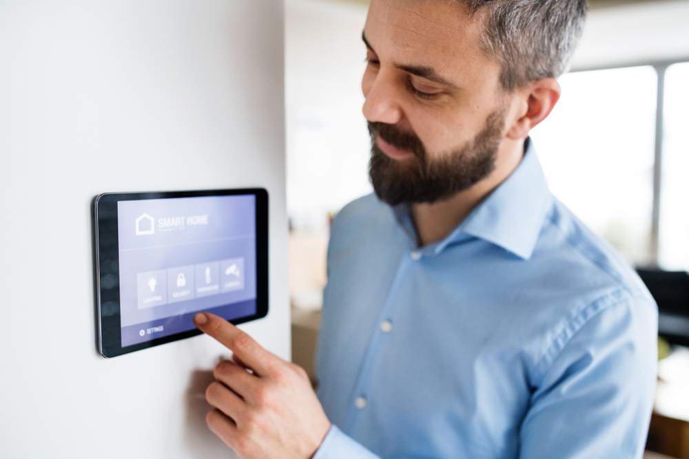 A man pointing to a tablet with smart home screen
