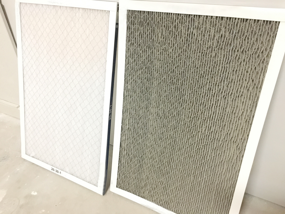 Clean air filter from HVAC unit next to a dirty one.