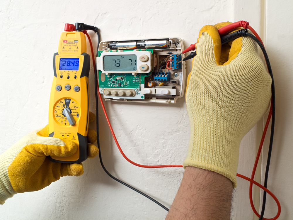 Air conditioning technician testing thermostat