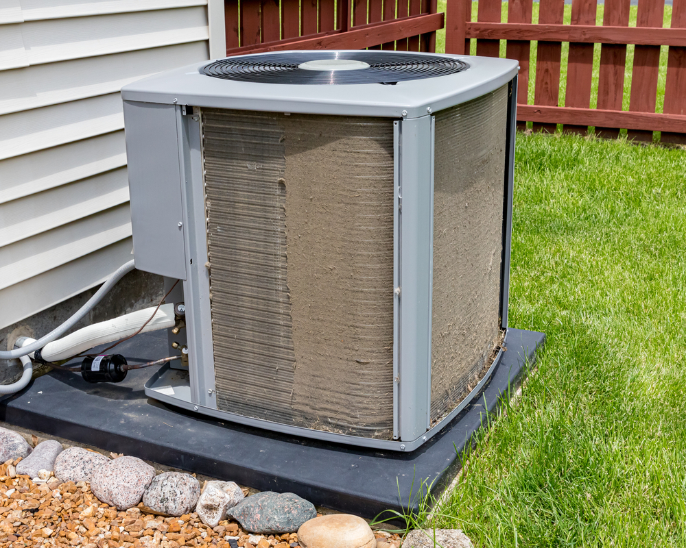 Half cleaned outdoor HVAC system, showing how much dust accumulates.