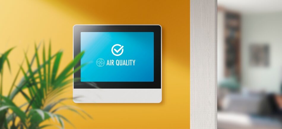 Monitor screen on yellow wall, displaying good indoor air quality